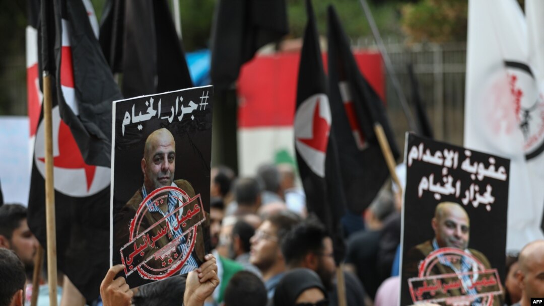 Former detainees of the pro-Israel South Lebanon Army (SLA) militia hold posters depicting former SLA member Amer Fakhoury during a demonstration denouncing his return, outside the Justice Palace in the Lebanese capital, Beirut, Sept. 12, 2019. 