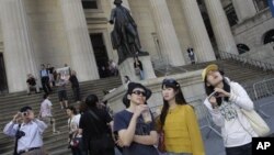 一群遊客在紐約股市交易所前合照(資料照片)
