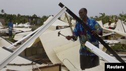 A man works to recover his personal possessions from his flattened home in a camp for displaced people in Port-Au-Prince, Haiti, August 25, 2012.