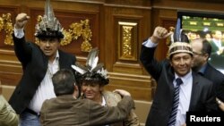 Julio Ygarza, left, Nirma Guarulla, center, and Romel Guzamana, deputies of the Venezuelan coalition of opposition parties, celebrate after their swearing-in ceremony during a session of the National Assembly in Caracas, Jan. 6, 2016.