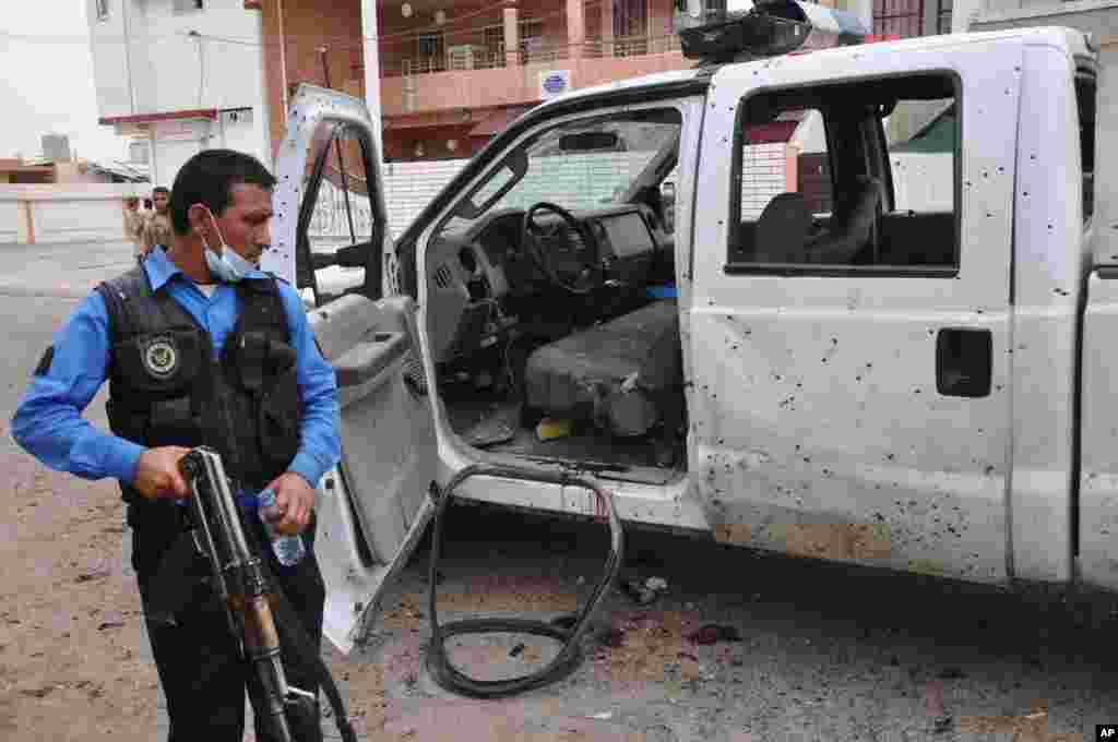 An Iraqi policeman inspects the site of a suicide attack at a polling center in Kirkuk, April 28, 2014.