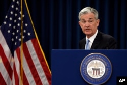 FILE - Federal Reserve Chair Jerome Powell gathers his notes as he concludes his news conference in Washington, March 20, 2019.