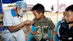 2008年6月1日,中國軍醫在四川省桃花山一處災民棲身營地為兒童注射甲肝疫苗。(資料照)
