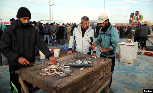 Men clean fish at a market in Gaza City, after Israel expanded fishing zone for Palestinians, April 2, 2019.