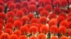 A girl laughs as she sits among hand fans during a mass performance at a children's martial arts fair in Foshan, Guangdong province, May 31, 2013. 