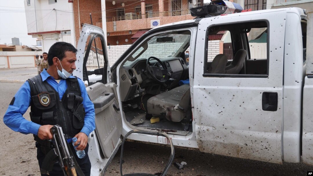 Polisi Irak memeriksa mobil yang hancur akibat ledakan bom bunuh diri dekat sebuah TPS di Kirkuk, Irak, Senin (28/4). Serangan hari Rabu (30/4) di Kirkuk saat pelaksanaan pemilu parlemen menewaskan 2 orang perempuan. 