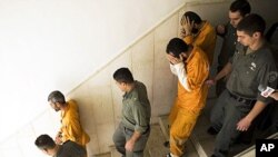 Palestinians suspected of killing Kristine Luken, an American tourist in December 2010, are escorted by Israeli security officers at the district court in Jerusalem, 26 Jan 2011