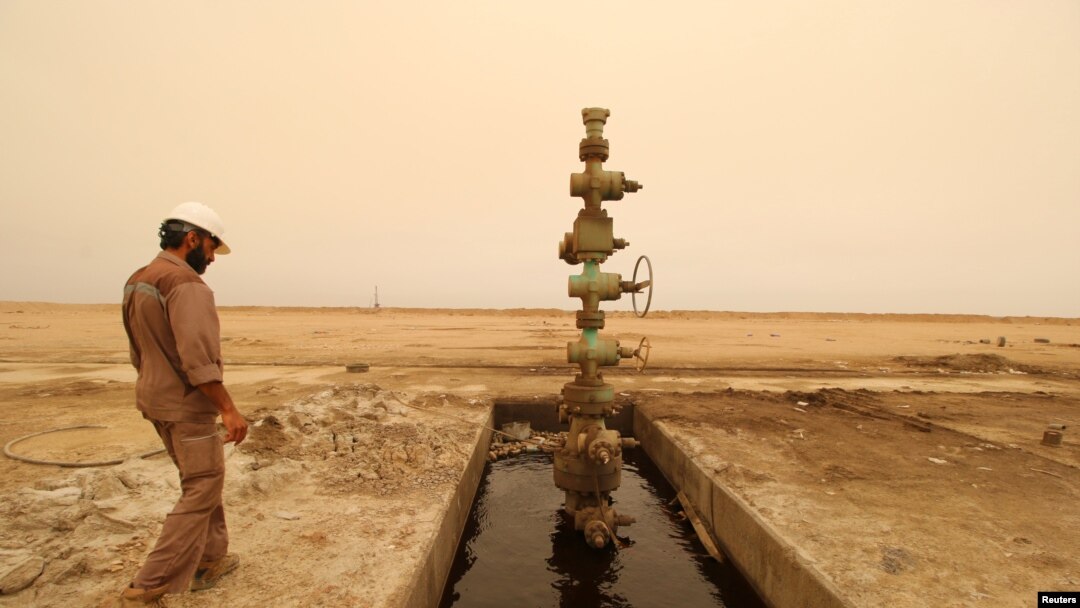 Seorang pekerja berjalan melewati sumur minyak di lapangan minyak Sindbad dekat perbatasan Irak-Iran di Basra, Irak, 23 April 2018.