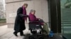 FILE - Gloria Taylor (R) enters the B.C Supreme Court with the help of Lee Carter, a fellow plaintiff in the case challenging the law regarding assisted-suicide in Vancouver, British Columbia on Dec. 1, 2011. Canada is announcing a new assisted-suicide law Thursday.