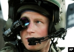 FILE - Prince Harry, or just plain Captain Wales as he is known in the British Army, wears his monocle gun sight as he sits in the front seat of his cockpit at the British controlled flight-line in Camp Bastion, Afghanistan, Dec. 12, 2012.