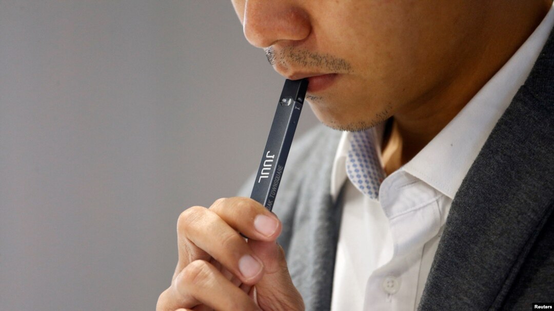 Seorang petugas toko menunjukkan cara menghisap rokok elektrik merek Juul kepada konsumen di sebuah toko Juul di Jakarta, pada 30 Desember 2019. (Foto: Reuters/Ajeng Dinar Ulfiana)