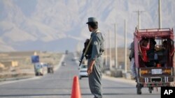 FILE - An Afghan policeman stands guard at a checkpoint on the outskirts of Mazar-i-Sharif, in Balkh province, Sept. 5, 2015.