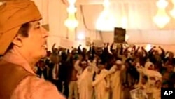 This video image broadcast on Libyan state television Sunday Feb. 20, 2011 shows longtime Libyan leader Moammar Gadhafi appearing with numerous supporters in Tripoli, Saturday Feb. 19, 2011.