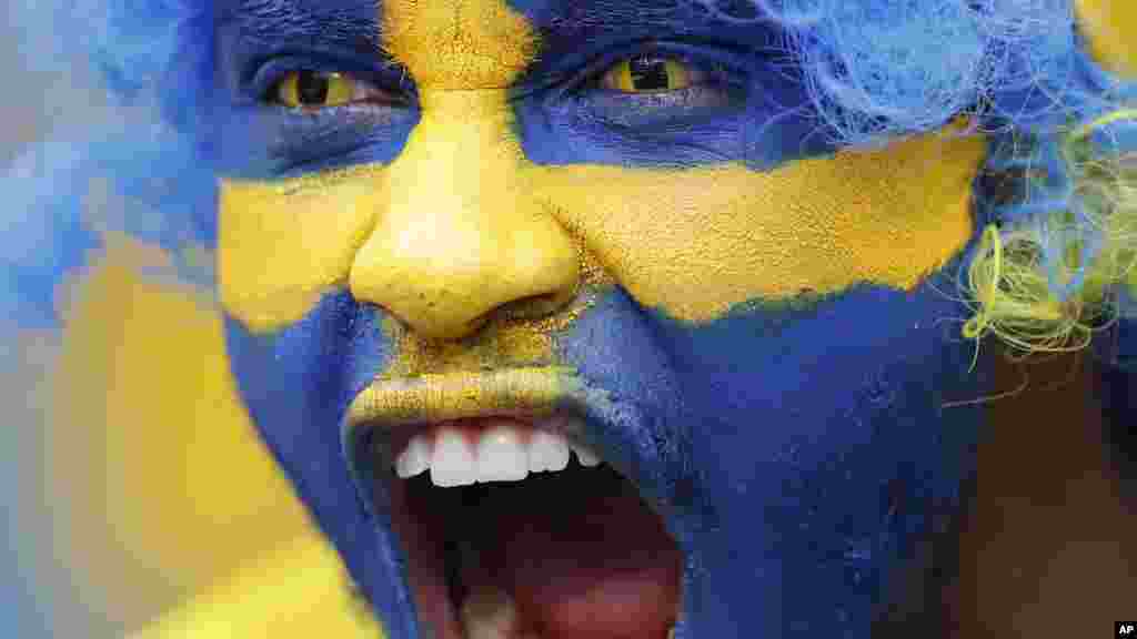 Un supporter de l' équipe nationale de la Suède, peint son visage aux couleurs du drapeau de son pays, le 13 juin 2016.
