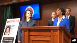 Prosecutor Ryann Jorban, left, who is on the immigrant fraud unit, looks on as District Attorney Jackie Lacey announces prosecutions during a news conference in Los Angeles, Feb. 12, 2019.