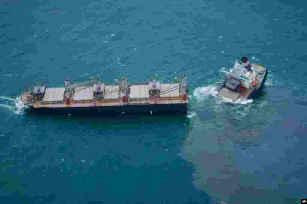 This photo provided by the Japan Coast Guard shows the Panamanian-registered cargo ship, Crimson Polaris, which ran aground, broke apart, and is leaking oil, off Hachinohe, Japan.