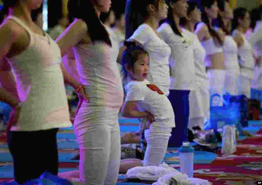 A child performs yoga at a hotel banquet hall to mark the International Yoga Day, in Changping District, on the outskirts of Beijing, China, Sunday, June 21, 2015. Yoga enthusiasts bent and twisted their bodies in complex postures across India and much of