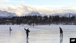 FILE - Ice skaters take advantage of unseasonable warm temperatures to ice skate outside at Westchester Lagoon in Anchorage, Alaska, Jan. 2, 2018. While a large part of the county is freezing under Alaska-like conditions, parts of the nation's northernmost state were basking in balmy conditions.