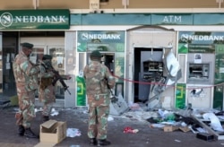 Des militaires devant une banque vandalisée.
