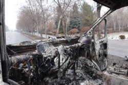 Sebuah mobil terbakar di dekat gedung administrasi di pusat Almaty, setelah kekerasan yang meletus menyusul protes atas kenaikan harga bahan bakar. (Foto: AFP)