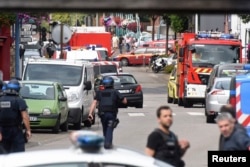 Police and rescue workers stand at the scene after two assailants had taken five people hostage in the church at Saint-Etienne-du -Rouvray near Rouen in Normandy, France, July 26, 2016.