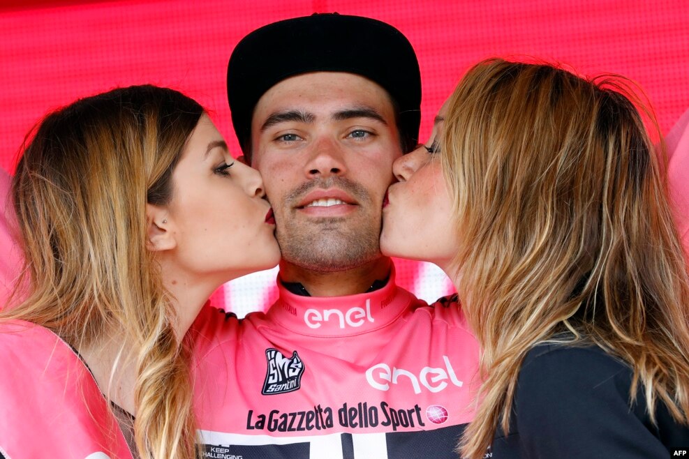 Two hostesses kiss Dutch cyclist Tom Dumoulin of Giant - Alpecin team as he bears the leader's pink jersey on the podium in the 7th stage of 99th Giro d'Italia, Tour of Italy, from Sulmona to Foligno in Foligno, Italy.