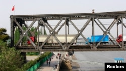  Trucks wait for border inspection at the Chinese end of the Friendship Bridge that connects Sinuiju, North Korea, with Dandong, Liaoning province, China, over the Yalu River, May 24, 2018.