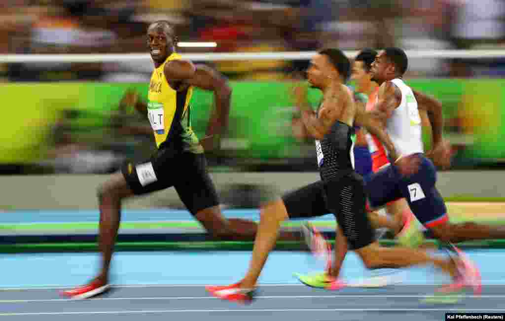 Bolt jette un coup d’œil sur ses poursuivants qu’il distance lors de la finale de 100 mètres hommes à Rio de Janeiro, Brésil, 14 août 2016. 