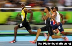 Jamaican sprinter Usain Bolt (in the lead) looks at the camera as he and other runners compete at the 2016 Olympics in Rio de Janeiro, Brazil. (Reuters Photo: Kai Pfaffenbach)