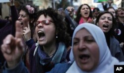 Egyptian women chant anti military ruling council slogans during a demonstration in front of the Journalist's Syndicate in Cairo, Egypt to mark International Women's Day, March 8, 2012.