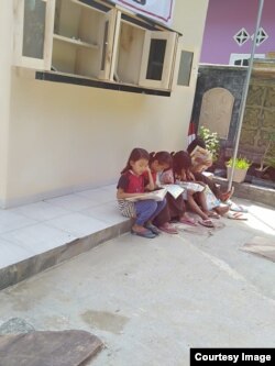 Anak-anak belajar membaca dengan buku dan majalah anak-anak di desa Rawajaya, Cilacap. Courtesy Ari Hendra Permana.