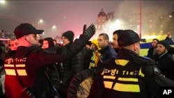 En esta imagen tomada de un video, la policía escolta a los seguidores del Maccabi Tel Aviv hasta la estación de metro que los lleva al estadio del Ajax, después de que simpatizantes propalestinos marcharan cerca del estadio, en Ámsterdam, Países Bajos, el 7 de noviembre de 2024.