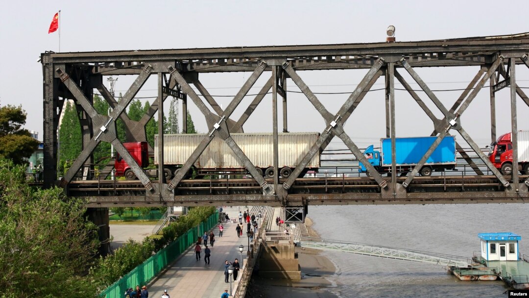 Antrian truk menunggu pemeriksaan perbatasan di ujung Jembatan Persahabatan (Friendship Bridge) yang menghubungkan Sinuiju, Korea Utara, dengan Dandong, provinsi Liaoning, China, di atas Sungai Yalu, 24 Mei 2018. (Foto: dok).