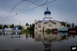 A church surrounded by water in a flooded neighborhood in Kherson, Ukraine, Thursday, June 8, 2023. (AP Photo/Evgeniy Maloletka, File)