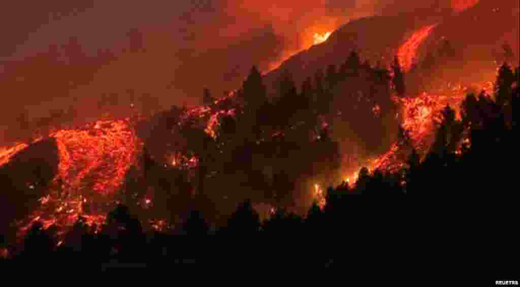 Lava mengalir dari gunung berapi di taman nasional Cumbre Vieja di El Paso, di Pulau Canary La Palma, Spanyol, Minggu 19 September 2021 (foto: tangkapan layar video / Reuters).