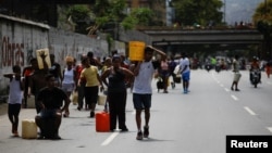 11일 베네수엘라 수도 카라카스의 고속도로에서 시민들이 강에서 길어온 물을 나르고 있다.