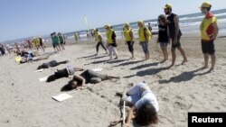 Aktivis Amnesty International ikut dalam sebuah aksi di pantai untuk memperingati Hari Pengungsi Sedunia di Valencia, Spanyol, 10 Juni 2015.