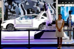 FILE - An industrial robot is displayed with car during the China Auto 2018 show in Beijing, China, April 26, 2018. Under President Xi Jinping, a program known as "Made in China 2025" aims to make the country a tech superpower.