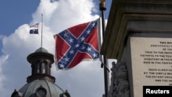 The U.S. flag and South Carolina state flag flies at half staff to honor the nine people killed in the Charleston murders as the confederate battle flag also flies on the grounds of the South Carolina State House in Columbia, SC, June 20, 2015.