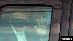 FILE - U.S. President Donald Trump waves to supporters as he briefly rides by in the presidential motorcade in front of Walter Reed National Military Medical Center, Oct. 4, 2020.