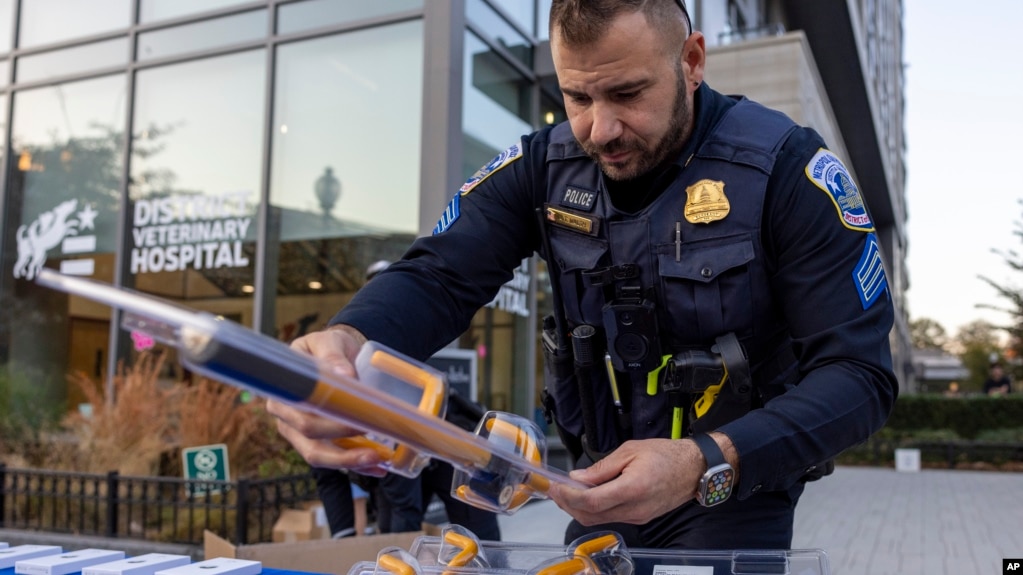 FILE - Metropolitan Police Department Sgt. Anthony Walsh sets out steering wheel locks at an anti-crime event in Washington on Nov. 7, 2023. A physical lock that attaches to the steering wheel can act as a visible deterrent to car thieves. (AP Photo/Amanda Andrade-Rhoades, File)