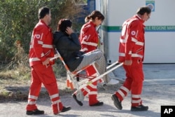 An earthquake survivor is carried by Red Cross staff in a tent camp set up as a temporary shelter following an earthquake in Pescara Del Tronto, Italy, Aug. 26, 2016.