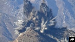 La imagen muestra una explosión durante el desmantelamiento de puestos de guardia surcoreanos en la zona desmilitarizada que divide la Península de Corea, en Cheorwon, el 15 de noviembre de 2018.