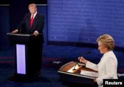 FILE - Republican presidential nominee Donald Trump listens as Democratic presidential nominee Hillary Clinton speaks during their third and final 2016 presidential campaign debate at UNLV in Las Vegas, Oct. 19, 2016.