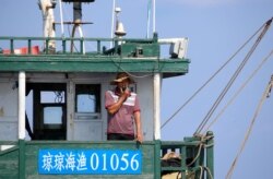 Seorang nelayan China di kapal ikan China di kawasan Karang Scarborough, 6 April 2017. (Foto: Reuters)