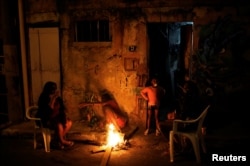 A family is pictured at the entrance of their house at a slum, or favela, in Rio de Janeiro, Brazil, June 26, 2016.