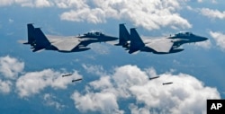 FILE - In this photo provided by South Korea Defense Ministry, South Korean air force F-15K fighter jets drop bombs as they fly over the Korean Peninsula during a joint drills with the U.S., Sept. 18, 2017. On Thursday, the air force said one of its F-15K