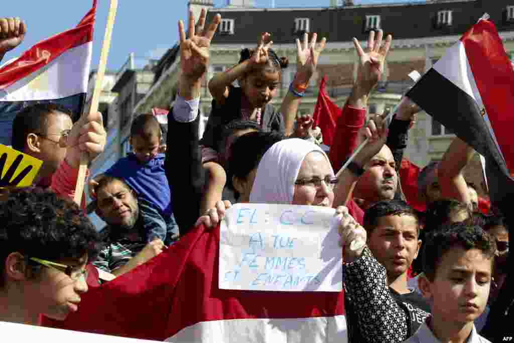 Demonstran memegang bendera nasional Mesir dalam protes atas kudeta militer terhadap presiden terguling Mohamed Morsi (18/8) di depan markas besar Komisi Eropa di Brussels, Belgia. (AFP/Belga/Nicolas Maeterlinck)