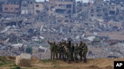 Soldados israelíes posan para una selfie en la frontera de la Franja de Gaza, en el sur de Israel, el lunes 19 de febrero de 2024. (AP Photo/Tsafrir Abayov).