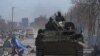 19일 우크라이나 남동부 항구도시 마리우폴 시내에서 부대 표식을 달지않은 친러시아 반군 장병들이 장갑차를 타고 이동하고 있다.